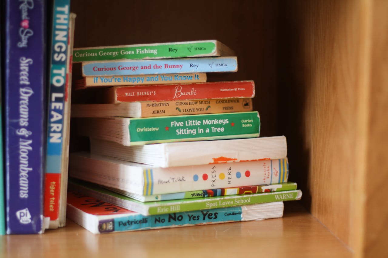 Colorful arrangement of childrens books on a wooden shelf, showcasing popular titles.